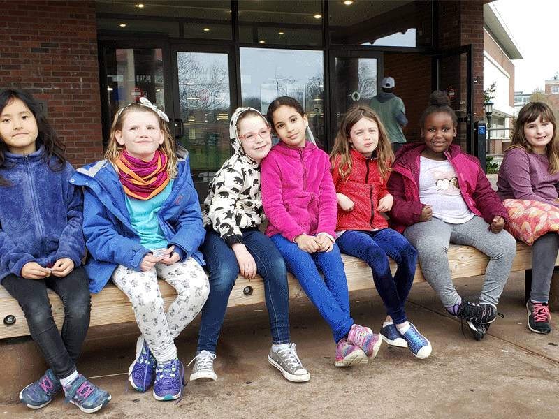 Slideshow of middle schoolers giving out cookies to UVM students in the library from 2011-2023.