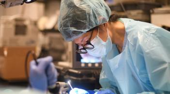 Masked clinician performing a procedure