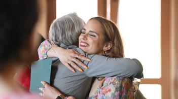 Student and dean hugging at awards reception.