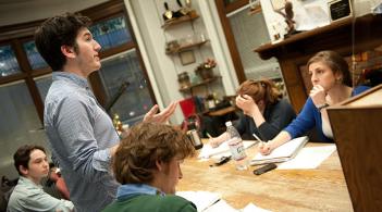 a group of students sit around a table debating