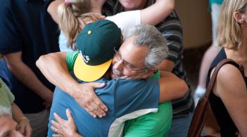 A student and parent embrace in a close hug.
