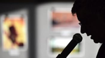 person in silhouette speaking into microphone