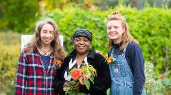 Three people posing for camera at a flower farm.