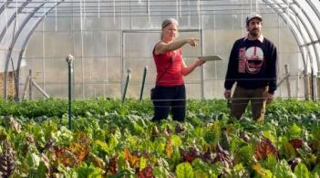 women pointing in a greenhouse