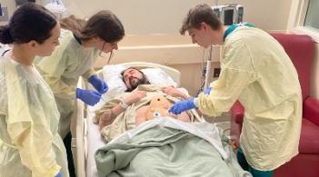 Nursing students work with standardized patient in simulation