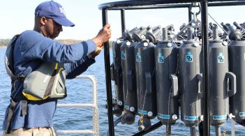 A Ph.D. student removing the water sampler from the lake.