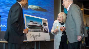 Marcelle and Patrick Leahy looking at a mock-up visual of the research vessel with Suresh Garimella.