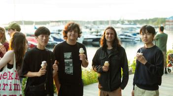 4 individuals smiling and eating soft serve ice cream