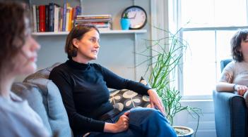 A counselor speaks with students in a group therapy setting
