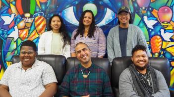 MCSC staff smiling infront of the colorful mural