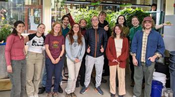 A group of UVM students in the RSENR ecodesign lab smiling and posing for a group photo