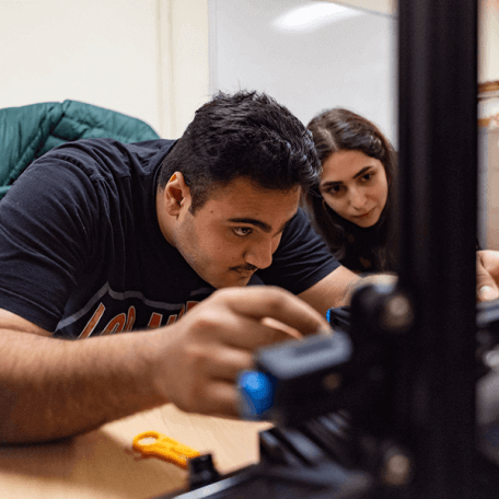  Two students work on building a drone