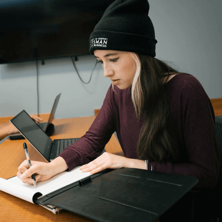 A student studies with their laptop and a notebook