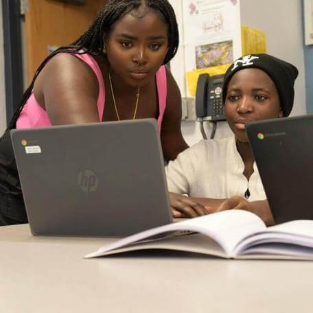 Two UVM students looking at something on the same laptop