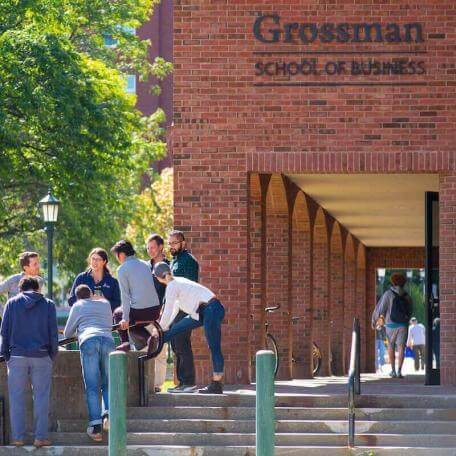 Students gather outside the Grossman School of Business during a break