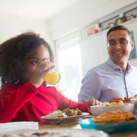 child and father at a table eating breakfast