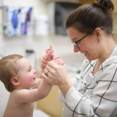 child and physician holding hands