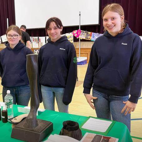 three hippology 4-h'ers at an exhibit table
