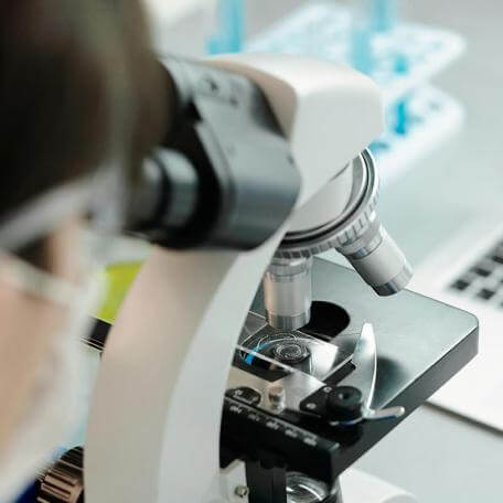 close-up of a person looking through a microscope
