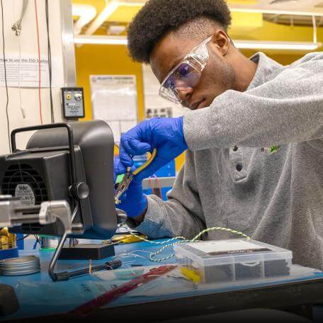 A student in the Electrical Engineering program works on his senior capstone project