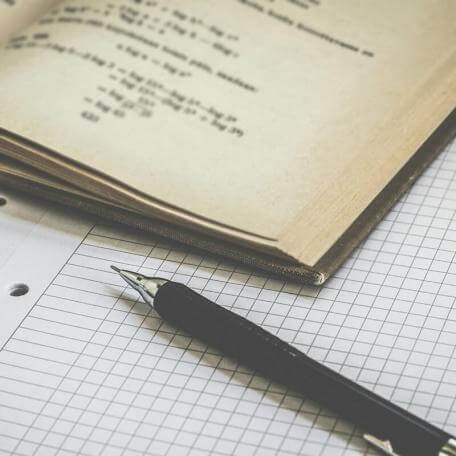 a pen and a book on some graph paper