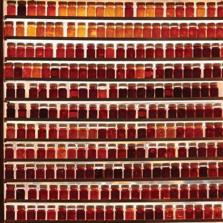 many shelves filled with small jars of maple syrup