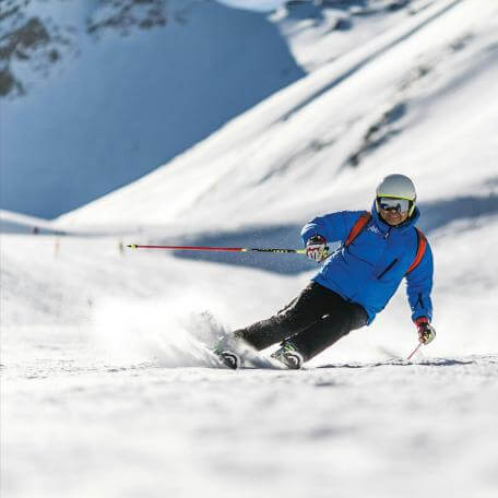 a skier slaloming down a snowy mountain