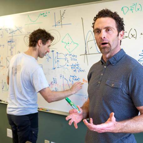 Professors teaching at a whiteboard