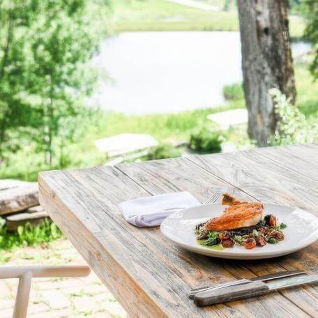 an outdoor table with a plate of food on it