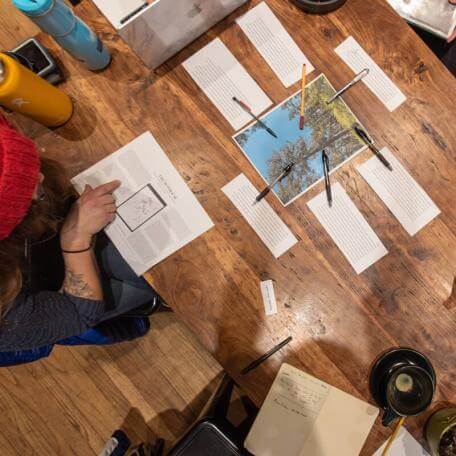 View looking down on a table with students working collaboratively in a writing workshop