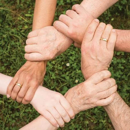 5 hands in a circle, grasping wrists