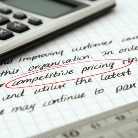 a piece of paper with marketing-speak written on it, under a calculator and a ruler
