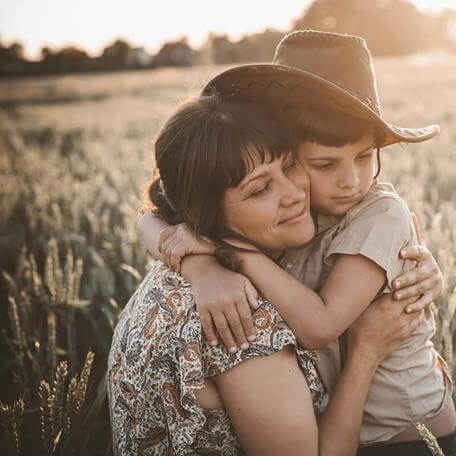 mother holding a child in a farm field