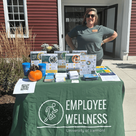 Cara Hancy sanding at a table of flyers and information