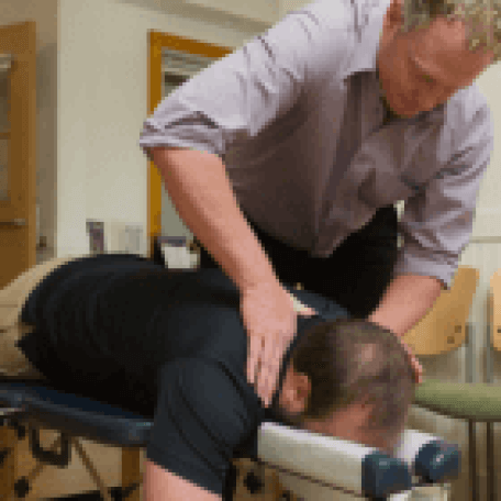 Doctor examining a prone patient's back