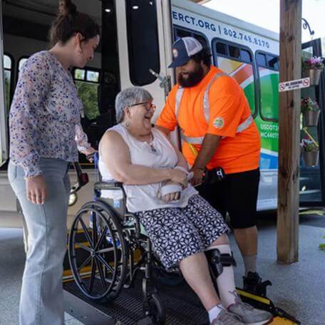 Transit employees helping a rider off the bus