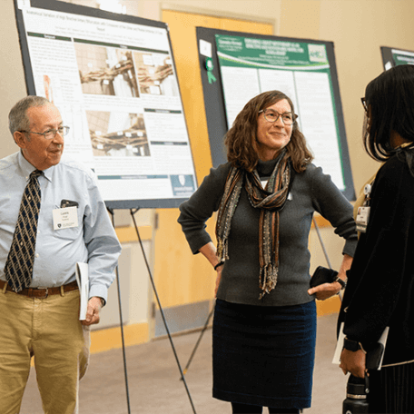 Three people standing in front of research posters