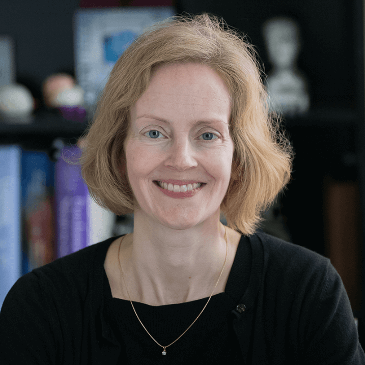 Alice, in portrait, smiling for the camera in an office setting