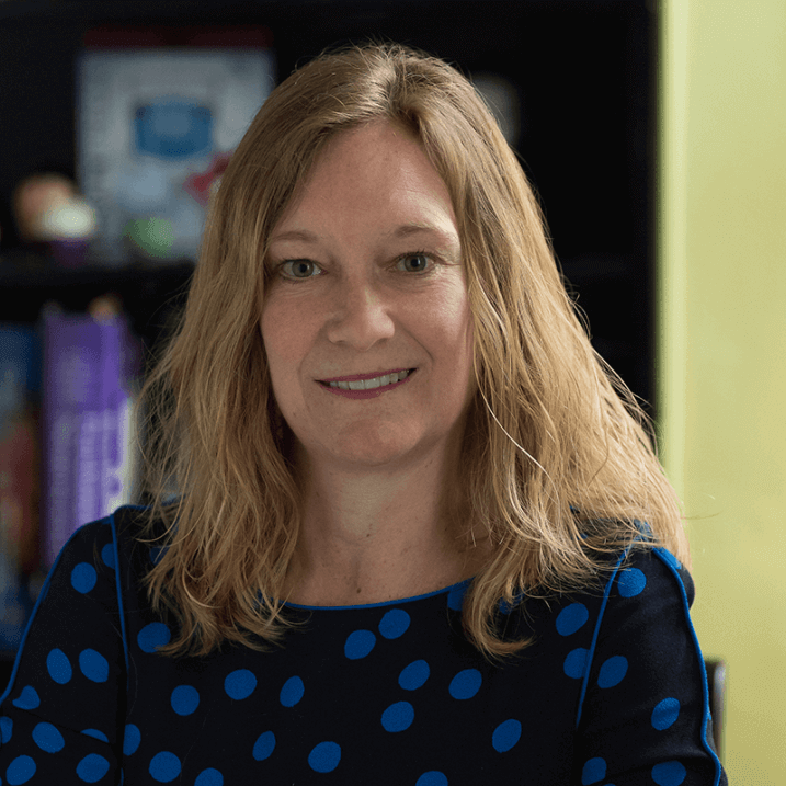 Kelly, smiling for the camera, in an office type setting
