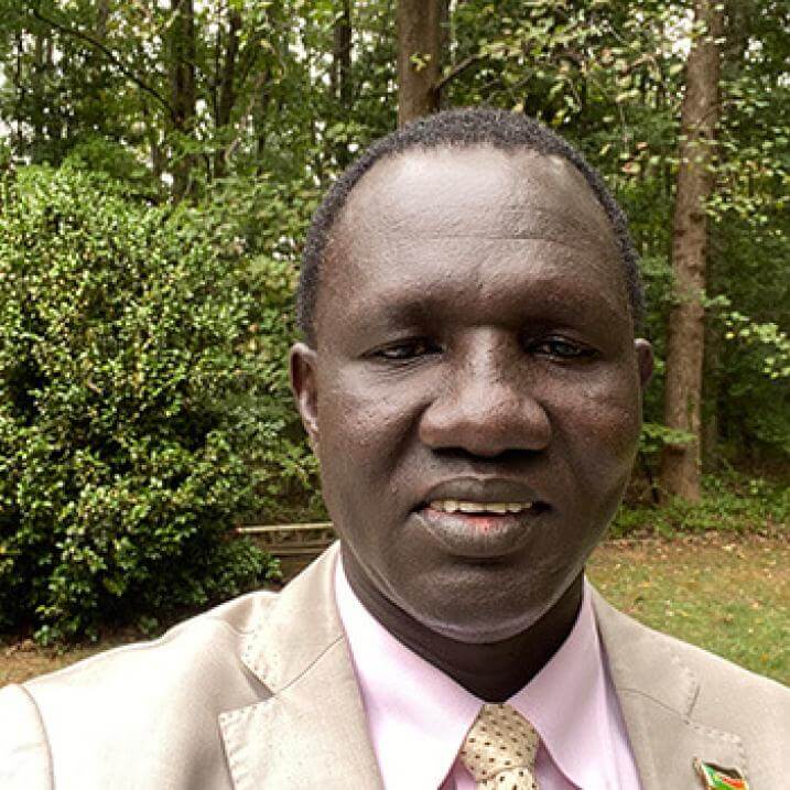 a headshot of a person in a tan suit
