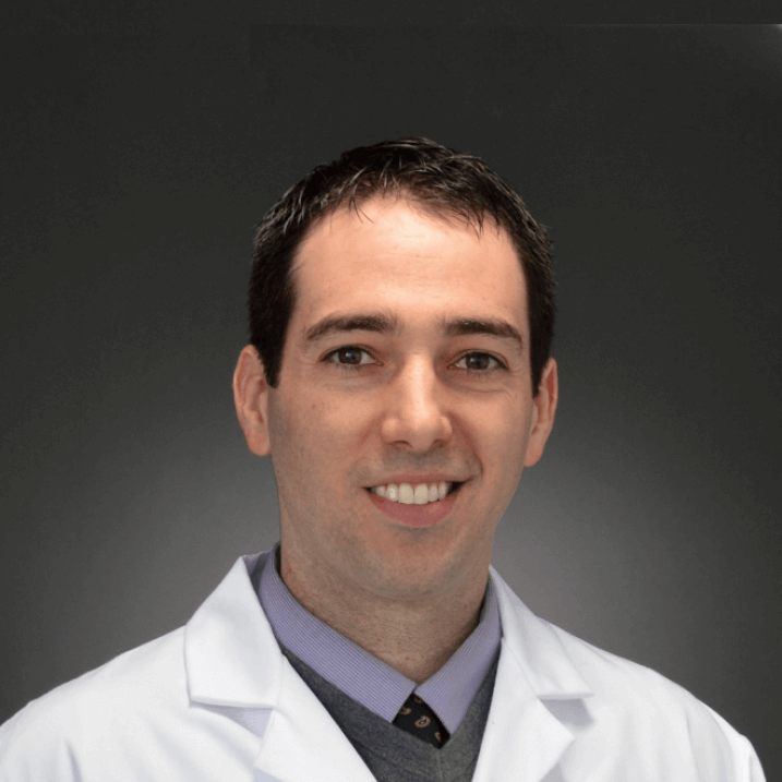 Researcher smiling posed against a grey background