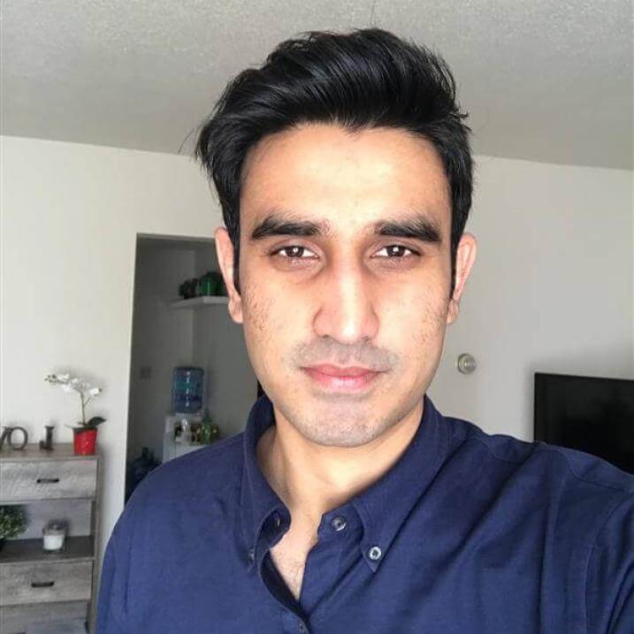 Ali is smiling wearing navy blue shirt 