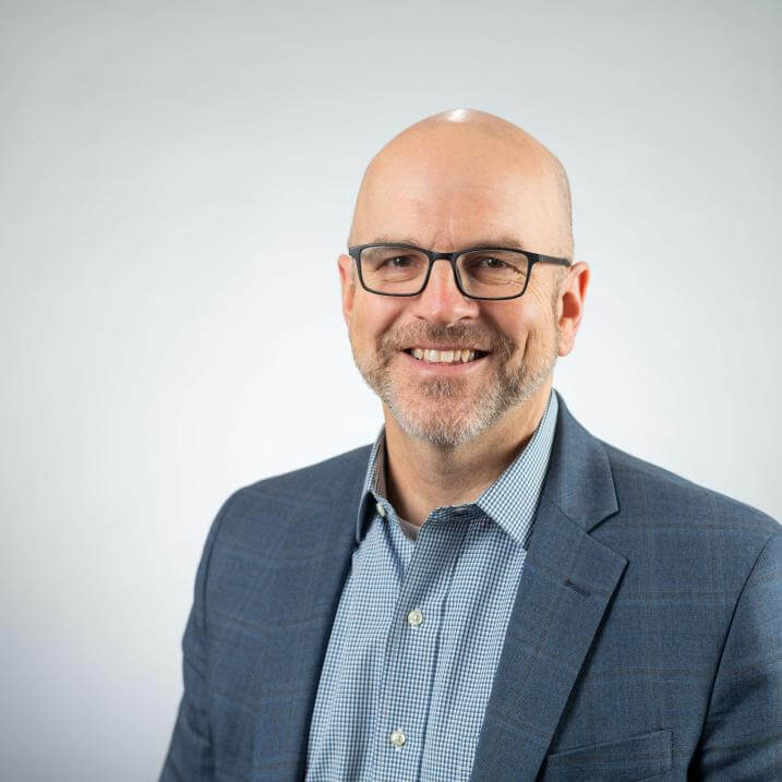 A person wearing glasses and a blazer