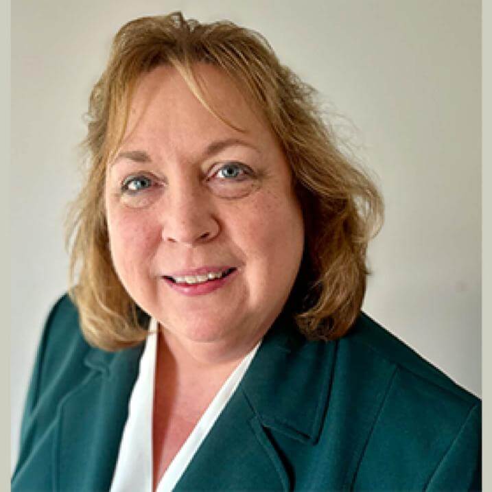 A person wearing a green blazer and a white shirt