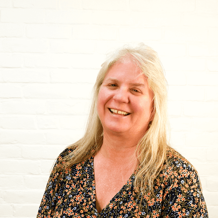 Smiling woman in front of a white brick wall