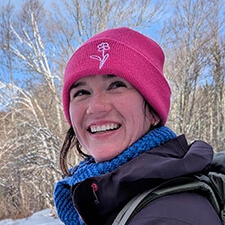 woman outside in the snow wearing a pink hat 