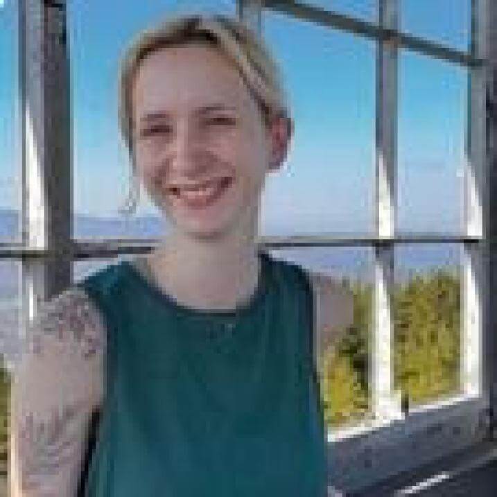Gwen smiling in front of a window