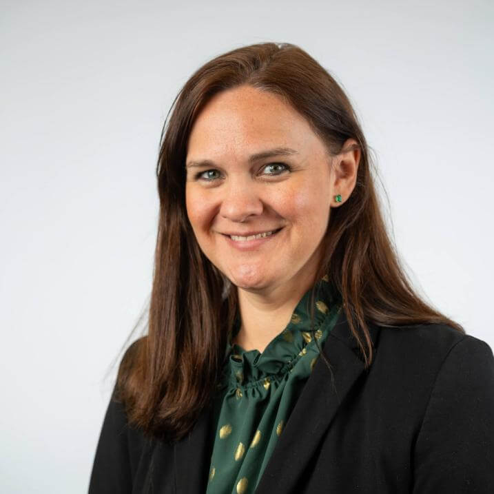 A person wearing a blazer and a scarf