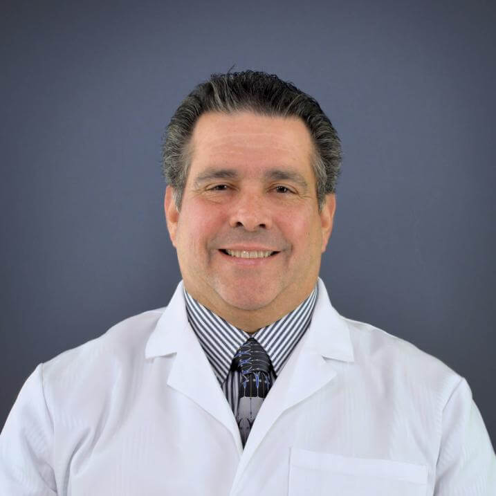 A person wearing a white coat and a tie