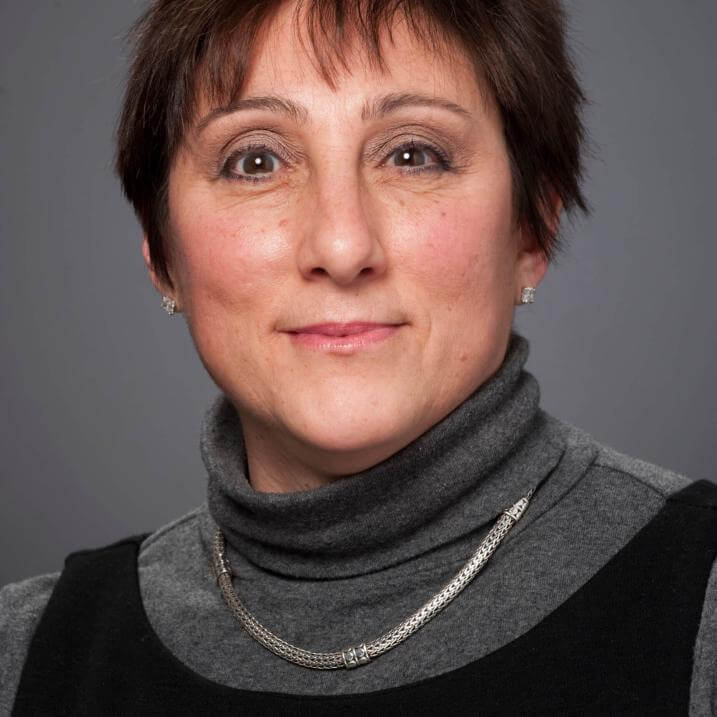 A person wearing a turtleneck and a necklace 